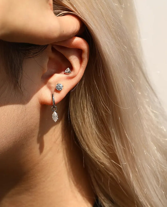 Moissanite Ørestikker i 925 Sølv - båret af en model, der stryger håret om bag øret