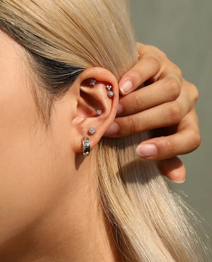 Moissanite Ørestikker i 925 Sølv - båret af en model, der stryger håret om bag øret