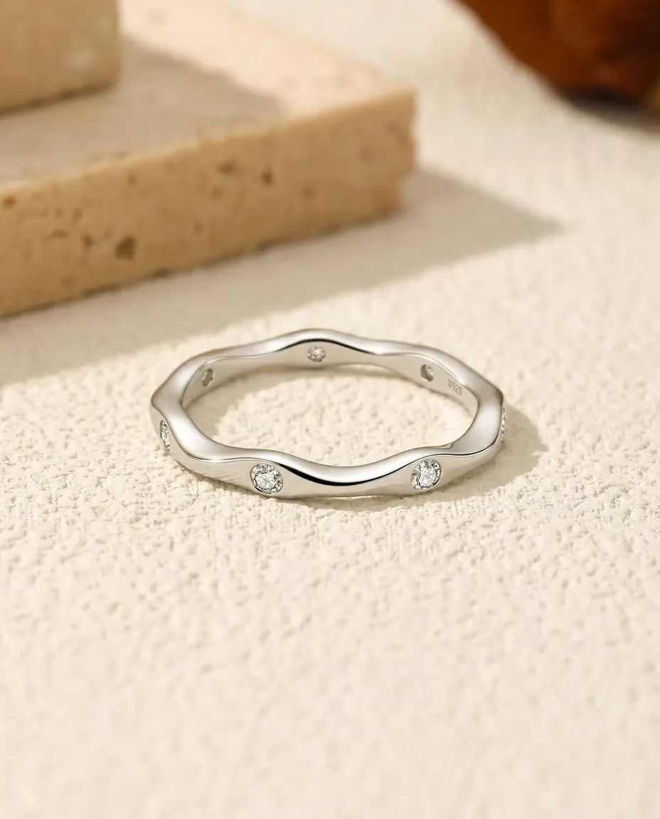 Moissanite Ring i 925 Sølv - liggende fladt på en lys struktureret flade