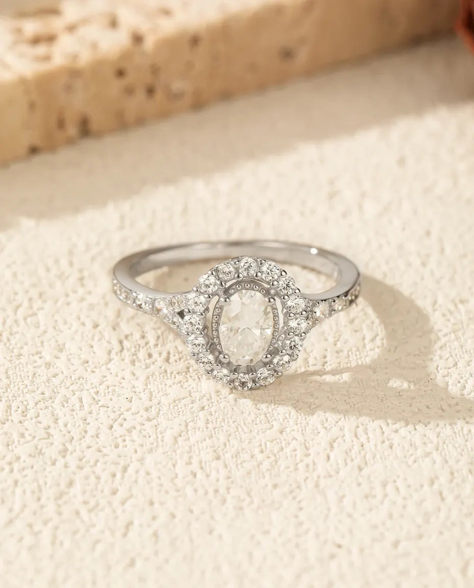Sølvring med oval moissanite omkranset af to rækker mikropavé og pavéskuldre i 925 sterling sølv.