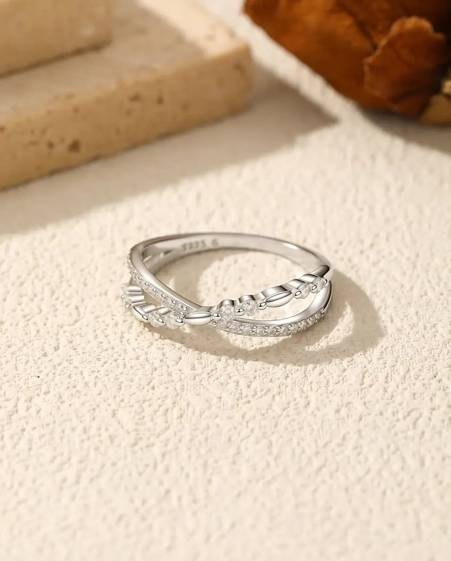 Sølvring hvor en pavélinje med moissanite-sten krydser en snoet rebskinne, i 925 sterling sølv.