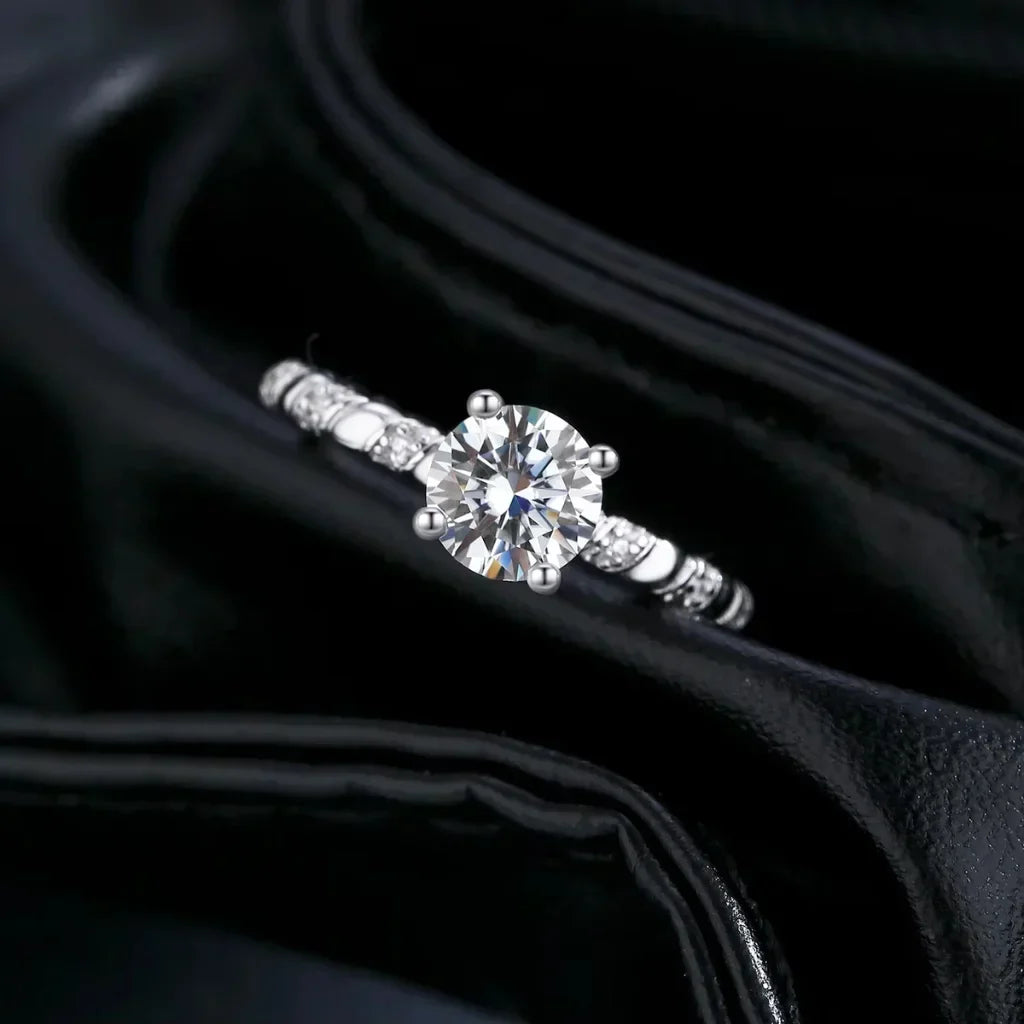 Sølvring med rund moissanite på en spiralsnoet skinne af to sammenflettede tråde i 925 sterling sølv.