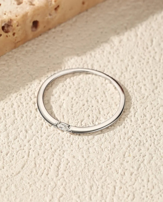 Smal sølvring med en enkelt marquiseslebet moissanite lagt på tværs af skinnen i poleret 925 sterling sølv.