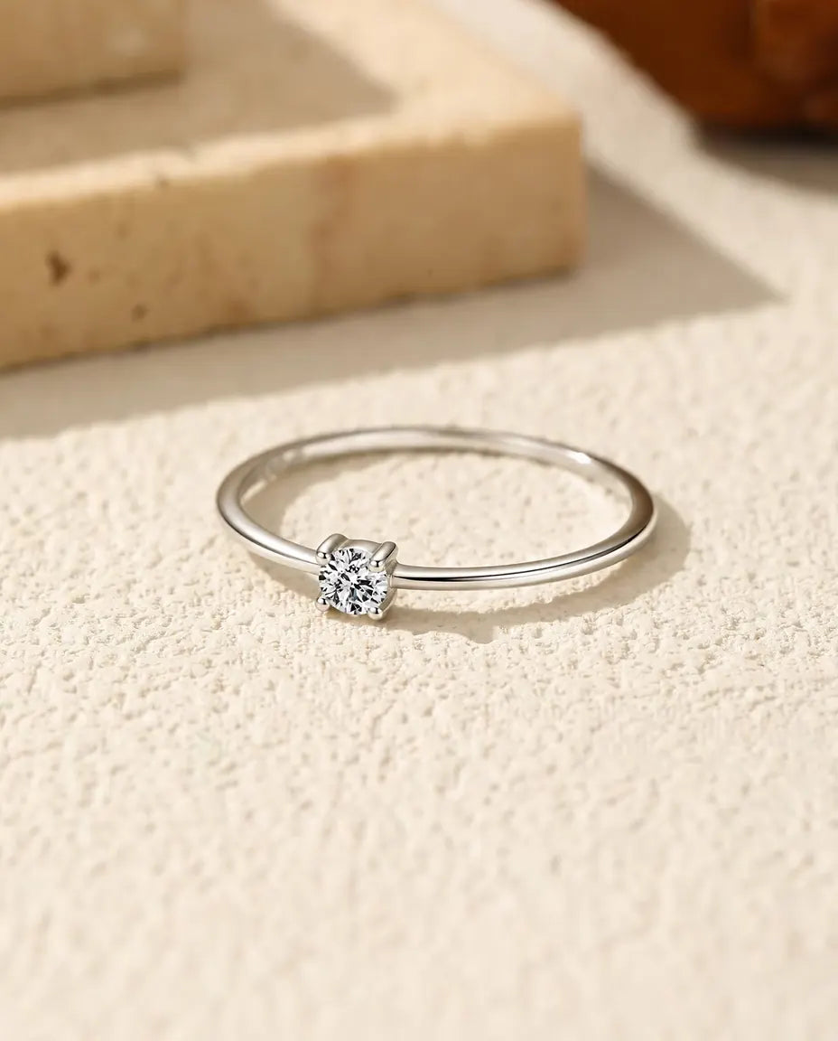 Moissanite Ring i 925 Sølv - liggende fladt på en lys struktureret flade