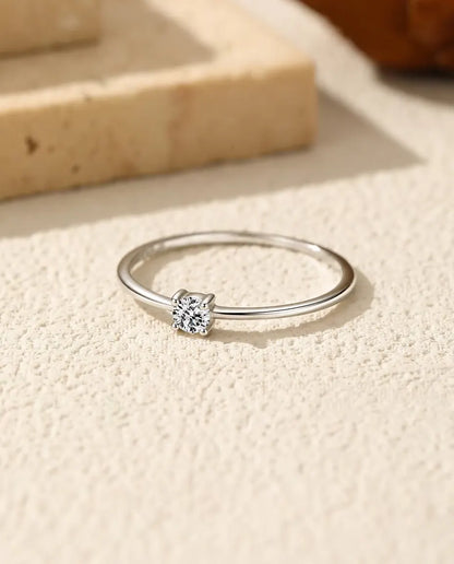 Moissanite Ring i 925 Sølv - liggende fladt på en lys struktureret flade