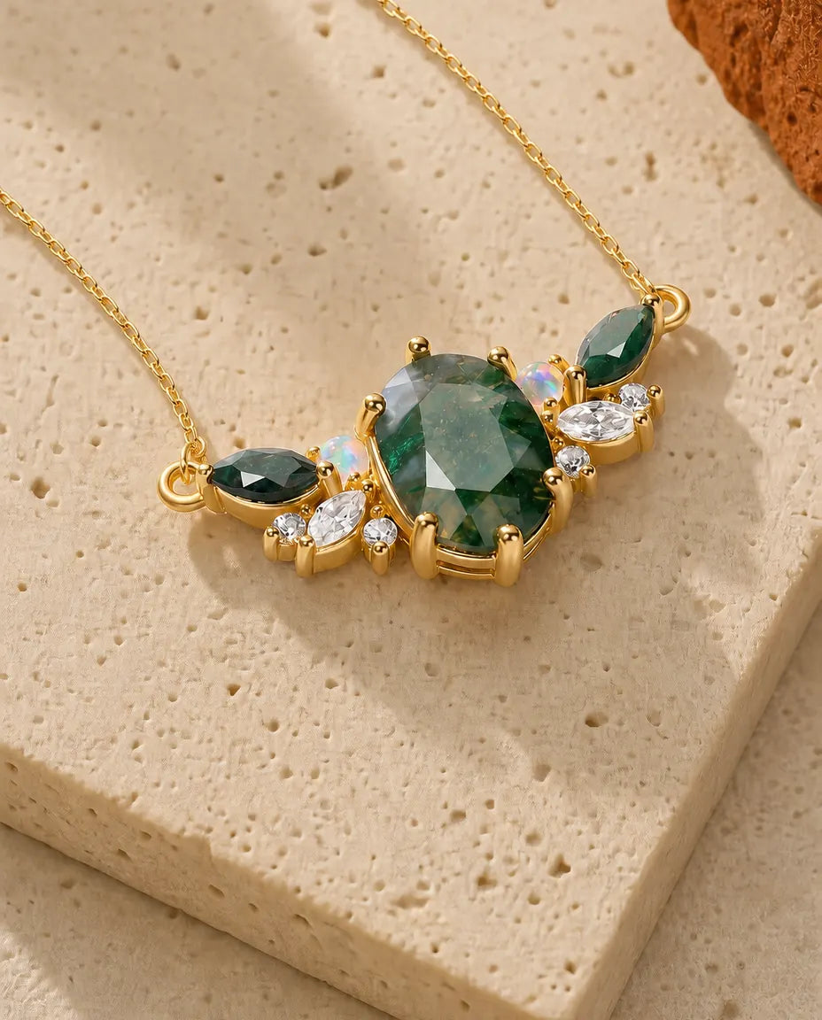 Guldbelagt vedhæng med oval grøn moss agate omgivet af mælkede opaler og hvide zirkoner.