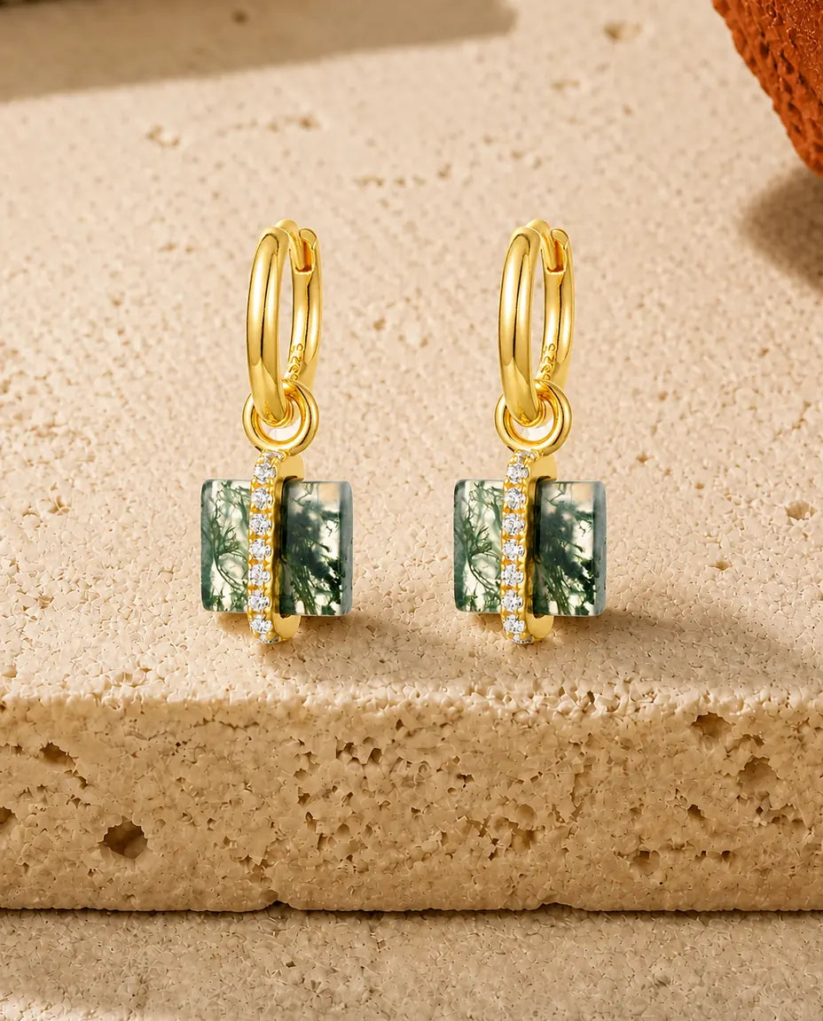 Guldbelagte creoler med en tyk firkantet grøn moss agate-blok og en skrå stang med små klare sten.