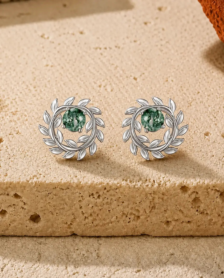 Ørestikker med en rund grøn Moss Agate midt i en krans af små hvælvede laurbærblade i poleret sølv.