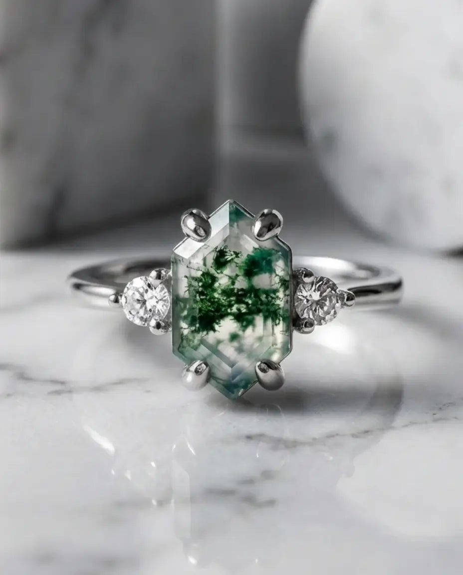 Justerbar ring med aflang hexagonslebet grøn moss agate mellem to runde zirkoner, i sølv, guld eller rosaguld.