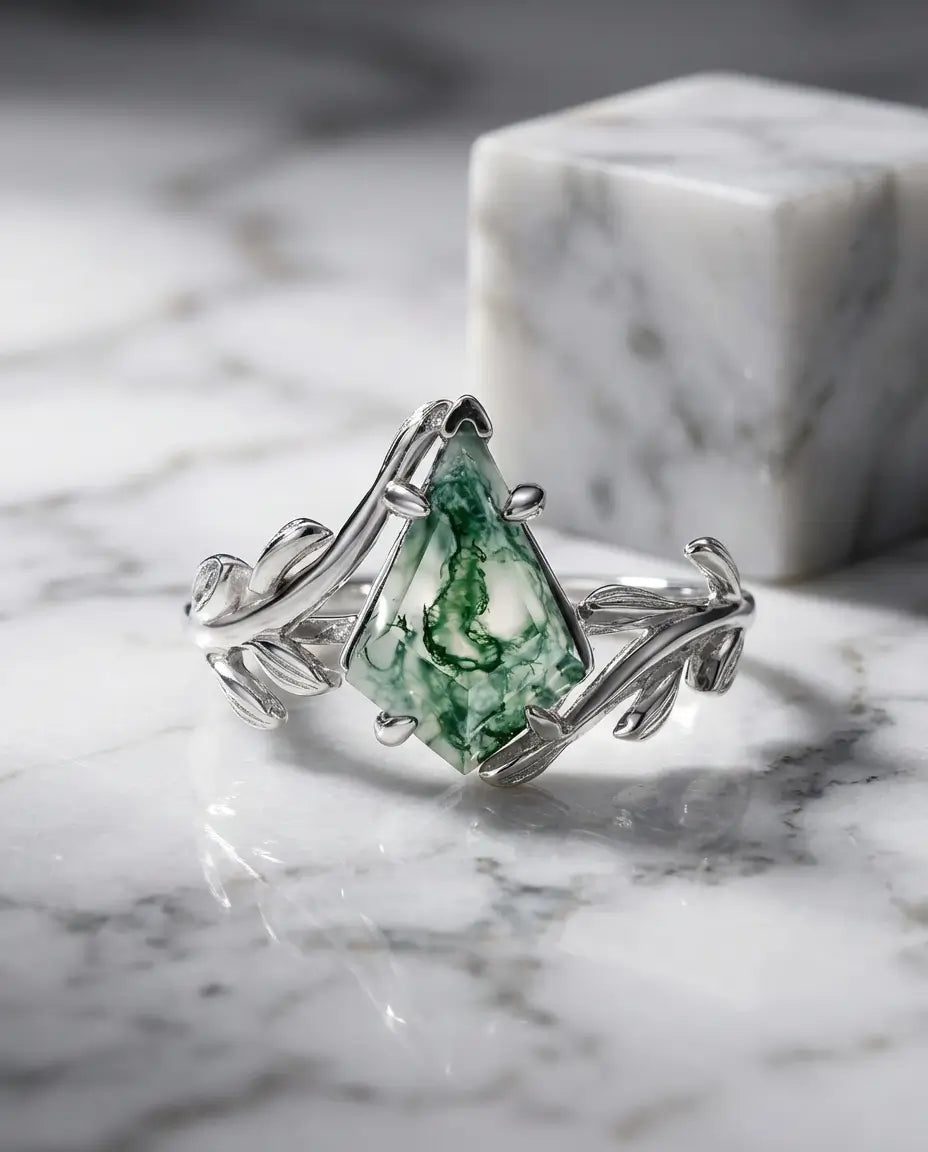 Sølvring med kite-slebet moss agate på en fatning formet som et blad i poleret 925 sterling sølv.
