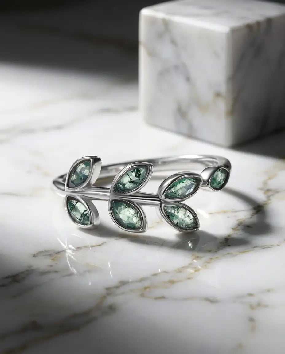Sølvring med små marquiseslebne moss agate-sten sat som blade langs en gren i hvidguldbelagt 925 sterling sølv.