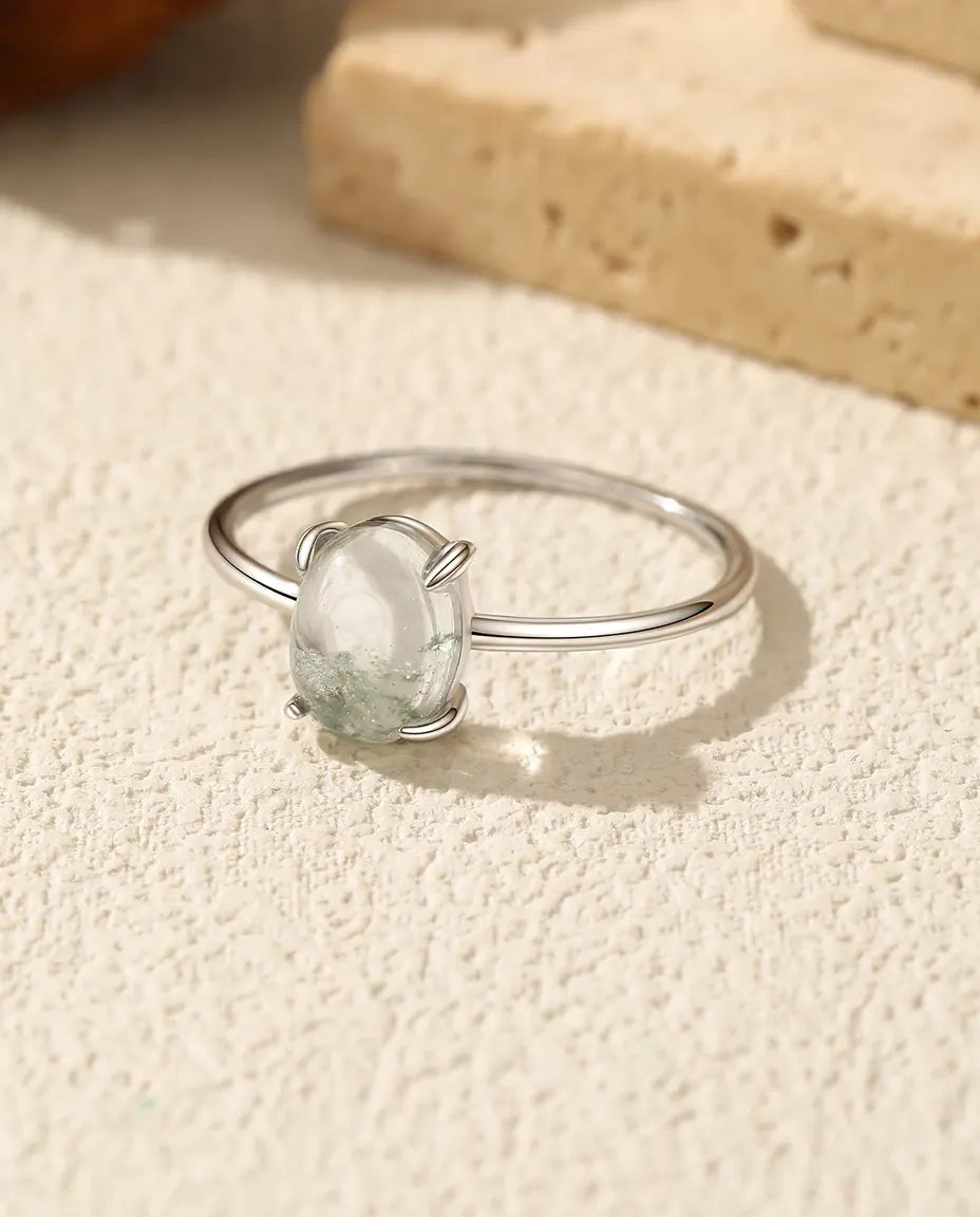 Spinkel sølvring med oval moss agate-cabochon på 6x8 mm i klofatning på en tynd skinne i 925 sterling sølv.