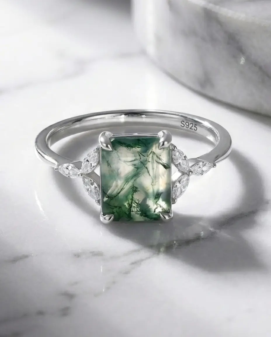 Sølvring med smaragdslebet grøn moss agate på 7x9 mm omkranset af marquiseslebne zirkoner i bladmotiv.
