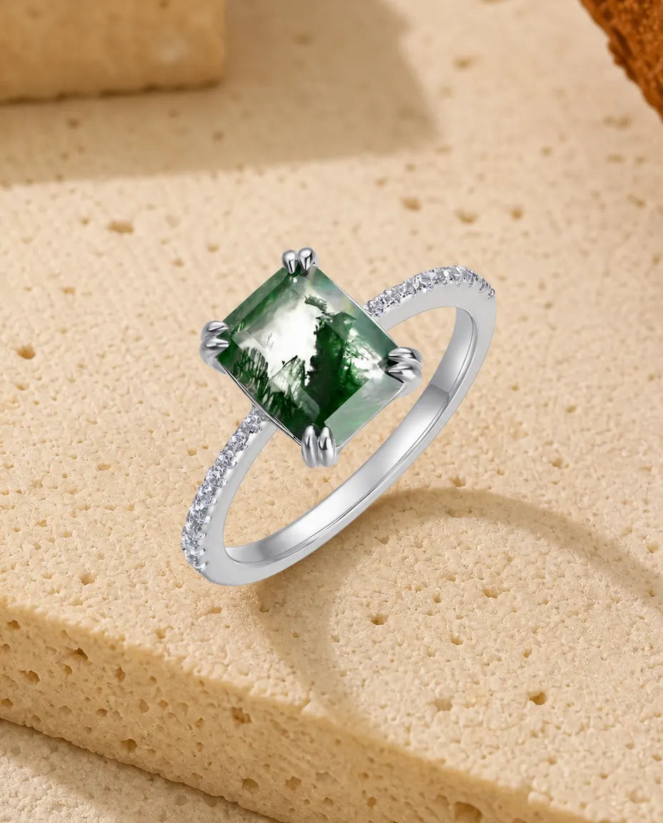 Sølvring med smaragdslebet grøn moss agate i dobbelte klør og hvide zirkoner på pavésatte skuldre.