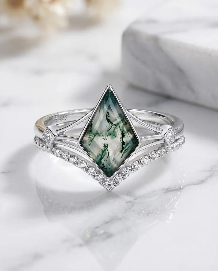 Ringsæt i 925 sterling sølv med kite-slebet moss agate og en buet medring med små zirkoniasten, der slutter tæt om stenen.