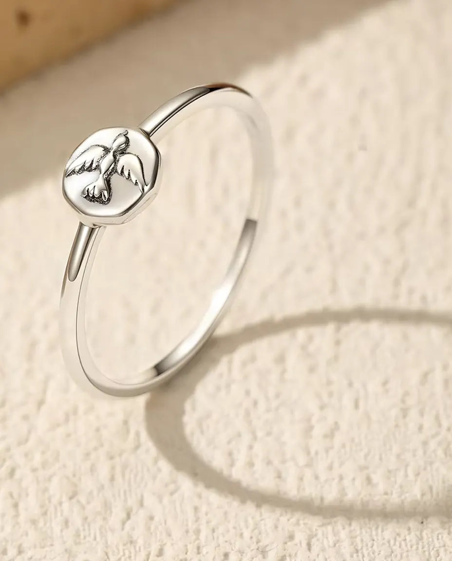 Tynd sølvsignetring med ottekantet plade og en due i relief, i massivt 925 sterling sølv.
