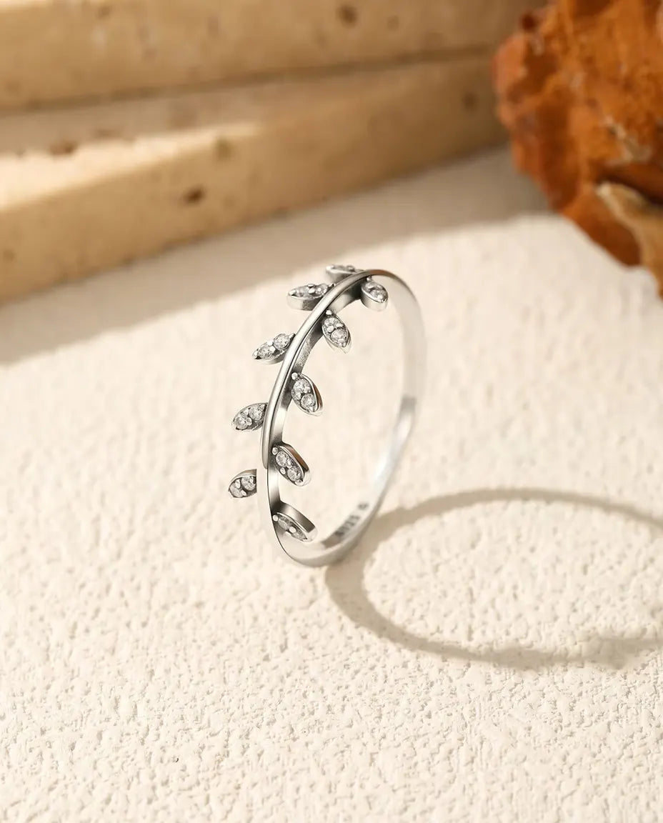 Smal sølvring med ti små blade sat med klare zirkoner langs den ene side af skinnen i 925 sterling sølv.